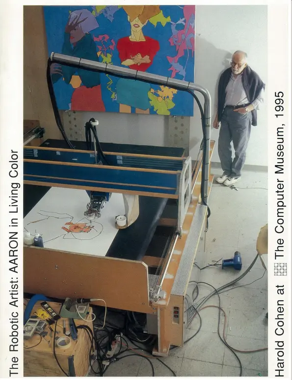 Harold Cohen looks on at a plotter machine (Aaron) plotting a drawing of a picture of a woman in orange and red, with a finished drawing mounted on the wall nearby