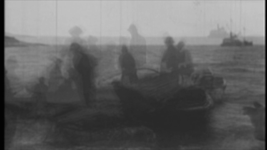Video screenshot from Distances showing people fairly transparent and decayed silhouettes standing on top of open water overlaid