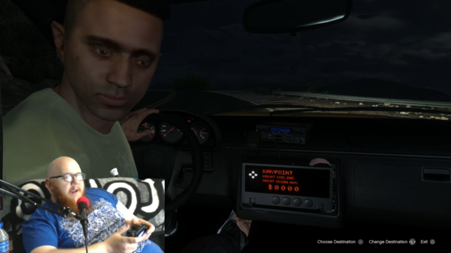 Screenshot of man livestreaming himself playing a video game, embedded on top of the game Grand Theft Auto V. We see a cab driver in his cab turn to us as passengers in the back seat.